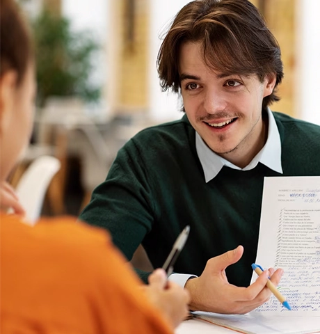 A smiling male student discusses documents with an abroad study consultancy Kerala